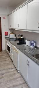 圣港Marear的厨房配有白色橱柜和台面