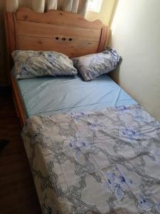 布琼布拉Kajaga Tanganyika的一张带木制床头板的床和两个枕头