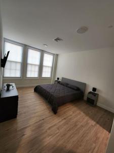 联城Close to NYC, 10 Guest, Luxurious 3Bedroom Apartment的卧室配有一张床、木地板和窗户。