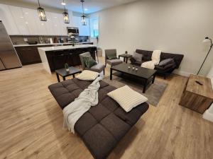 联城Close to NYC, 10 Guest, Luxurious 3Bedroom Apartment的带沙发和椅子的客厅以及厨房。