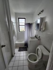 联城Elegant 2 bed gem! mins from NYC的白色的浴室设有卫生间和水槽。
