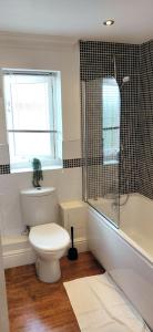 利明顿温泉Leamington Spa Warwick Place Apartments的一间带卫生间和淋浴的浴室以及窗户。