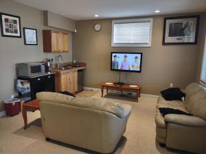 卡尔加里Spacious One Bedroom Walkout Basement Suite的客厅配有2张沙发和1台平面电视