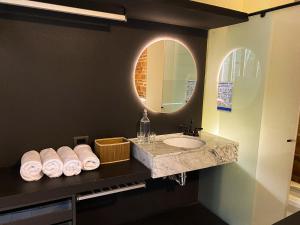 圣玛尔塔Casa Charlotte - Alma Hotels的浴室配有盥洗盆、镜子和毛巾