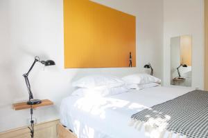里斯本Cheese & Wine Lapa的卧室配有白色床和黄色墙