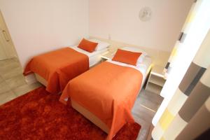 科沙林Apartamenty Ogrody的配有橙色床单的客房内的两张床