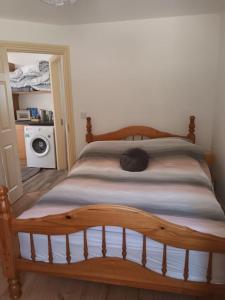 韦克斯福德Ivy Cottage的卧室内的一张木床,配有洗衣机