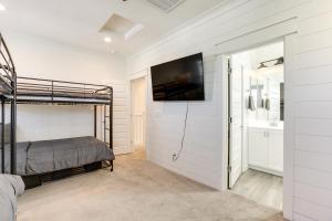 嘉年Goodyear Vacation Rental with Private Hot Tub的一间卧室配有一张双层床和一台墙上的电视。