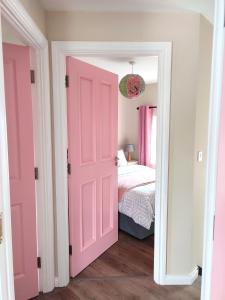 巴利纳Unboring Holiday Let, Ballina, Mayo的粉红色的门通向一间带床的卧室