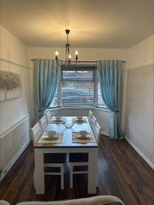 纽波特2 bedroom semi-detached house- sleeps 4的一间带桌椅和窗户的用餐室