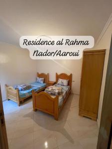 Monte ʼArrouitResidence al Rahma 05的一间设有两张床的房间和一个可读到卡玛纳达拉米的复原力的标志