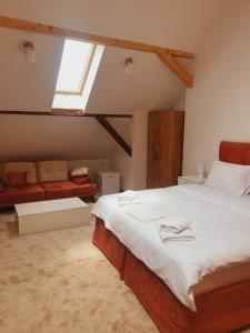 斯雷姆斯基卡尔洛夫奇Fruškogorski biser的一间卧室配有一张大床和一张沙发
