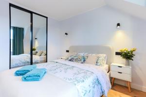 珀斯Luxurious City Centre Apartment的卧室配有白色的床和大镜子