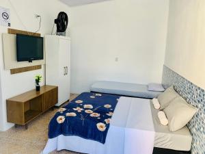 大普拉亚Pousada Aconchego Ocian的一间带床和电视的小卧室