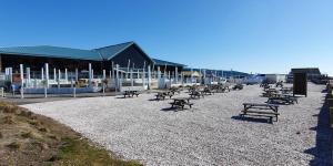 塞尔西Althea, White Horse, Seal Bay Resort的坐在海滩上,有一幢楼房的长椅