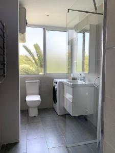 福恩吉罗拉Entre el verde y el azul的浴室配有卫生间水槽和洗衣机。