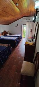 莫什港Alojamento Local Céu-Azul的客房设有三张床、一张桌子和一张桌子。