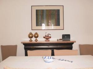 帕罗斯岛The Kamari Blue Dome house的一间用餐室,配有一张桌子和一张墙上的照片