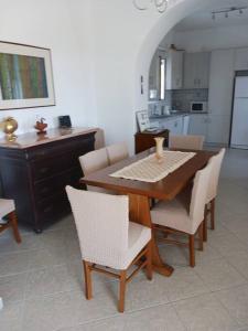 帕罗斯岛The Kamari Blue Dome house的餐桌、椅子和厨房