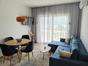 昆博White Apartment的客厅配有蓝色的沙发和桌子