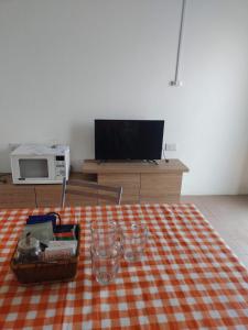 圣罗莎Lo de Bibi的客厅配有带毯子的桌子和电视