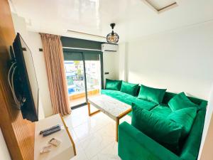 米迪克Luxury SuiteMar的客厅配有绿色沙发和桌子