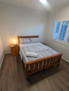 布里斯班Immaculate 2-Beds Entire House Chermside Brisbane的一间卧室配有一张带木制床架的大床