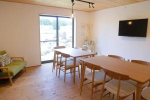 信浓1日1組様限定 黒姫山の絶景を楽しむ貸切サウナ付き一軒家的客厅配有桌椅和电视。