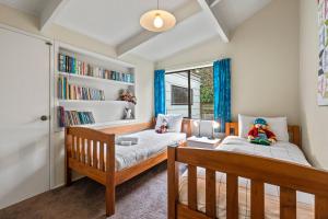 陶波Greenhaven with wi-fi的一间卧室设有两张床和书架