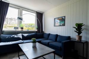 雷讷Reine Basecamp - Apartments & Rooms的客厅配有蓝色的沙发和桌子
