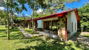 塔拉波托Villa Sebastiana Bungalows的公园里一座红色屋顶的小建筑