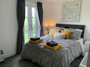 达灵顿Newbus Grange Lodge The Cottage的一间卧室配有一张大床和黄色枕头