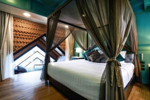 清迈The Moment Chiangmai的一间卧室配有一张带天蓬的床