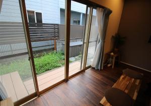东京HIDAKA STAY VILLA 柴又的客房设有带大型滑动玻璃门的阳台。
