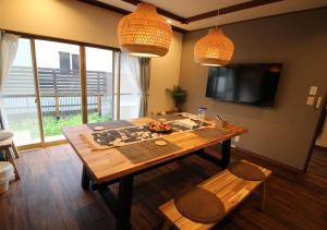 东京HIDAKA STAY VILLA 柴又的客厅配有木桌和电视。