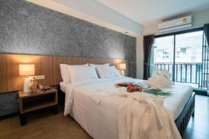 曼谷The Home Hotel SHA的卧室设有一张白色大床和大窗户