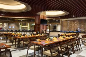 巴淡岛中心Panbil Residence Serviced Apartment的一间带木桌椅的餐厅和一间酒吧