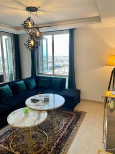 拉合尔AirReside Hotel Apartments Gold Crest的客厅配有蓝色的沙发和桌子