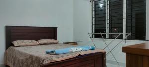 特里凡得琅Luxurious Apartment with a pool and gym near Trivandrum railway station的一间卧室设有一张大床和大窗户