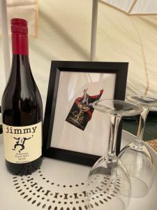 亚拉腊Cosy Glamping Tent 3的桌子上放有一瓶葡萄酒和两杯酒