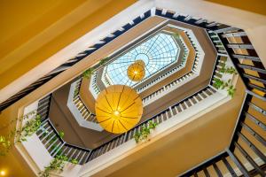 会安Lantana Riverside Hoi An Boutique Hotel & Spa的享有螺旋楼梯上方的黄色伞形美景
