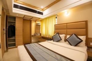 马杜赖Hotel Grand Sabarees的一间卧室配有一张大床和一个衣柜