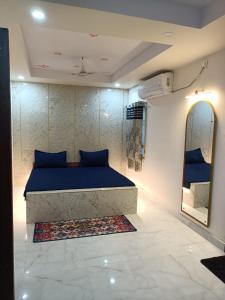 BrahmapurHotel HCB (Hemo Chandra Bhawan)的一间卧室配有蓝色的床和镜子