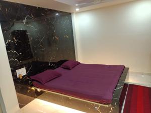BrahmapurHotel HCB (Hemo Chandra Bhawan)的卧室配有一张壁挂式紫色床