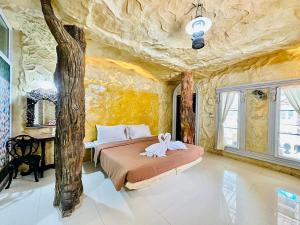 塞友Yoko River Kwai Resort的卧室配有一张石墙内的大床