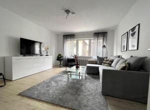 门兴格拉德巴赫Gemütliche Wohnung mit Stil 5 Sterne的带沙发和电视的客厅