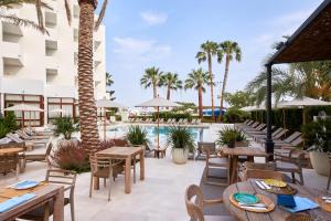 圣埃乌拉利亚特雷斯托雷斯酒店的一个带桌椅的户外庭院和一个游泳池