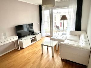 圣叙尔皮斯Cape Homes St-Sulpice的客厅配有白色沙发和平面电视。