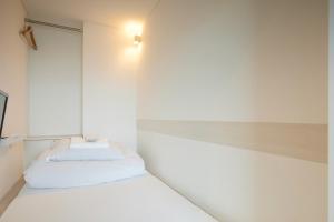 鸟取市鸟取德罗普旅舍的卧室配有两张床,墙上有灯