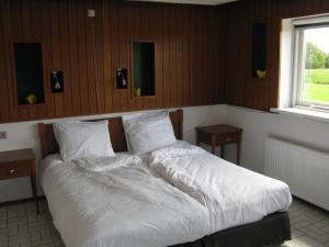 瓦尔德瓦坎沃德度假屋的一间卧室配有带白色床单和枕头的床。